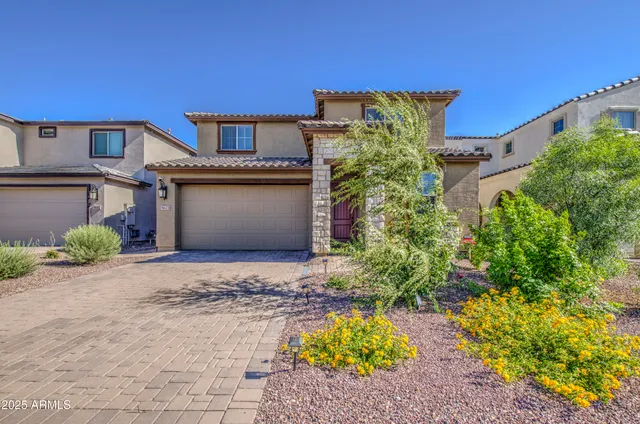 a front view of a house with a yard and a garden