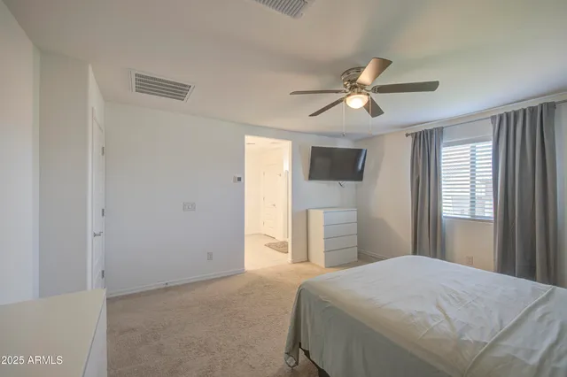 a bedroom with a bed and a ceiling fan