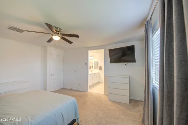 a bedroom with a bed and a ceiling fan