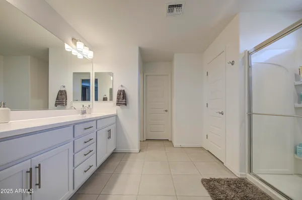 a spacious bathroom with a double vanity sink a mirror and a bathtub