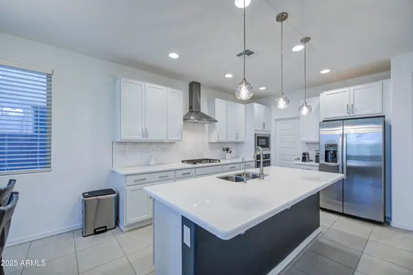 a kitchen with a sink a counter top space stainless steel appliances and cabinets