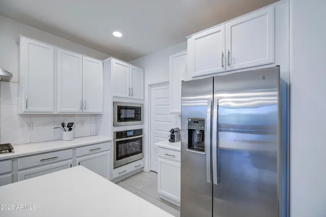 a kitchen with a sink a counter top space stainless steel appliances and cabinets
