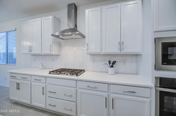 a kitchen with white cabinets and a stove with a sink