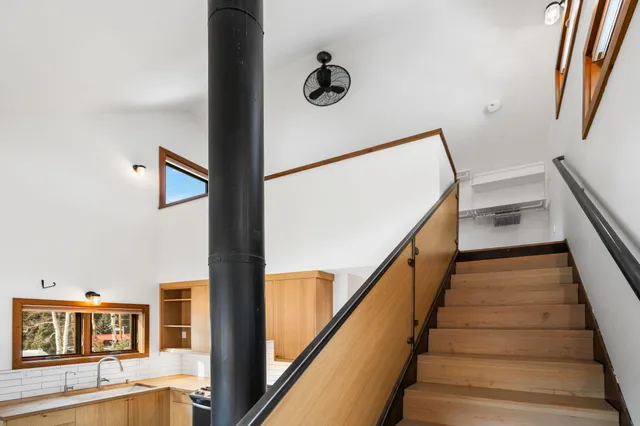 a view of staircase with lots of frames on wall and a rug