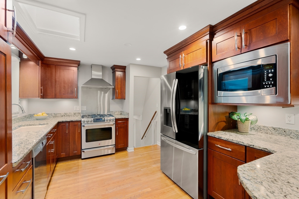 73 Willow Road Sudbury, MA 01776 - Photo 11 of 41 a kitchen with stainless steel appliances granite countertop a stove a sink and a refrigerator