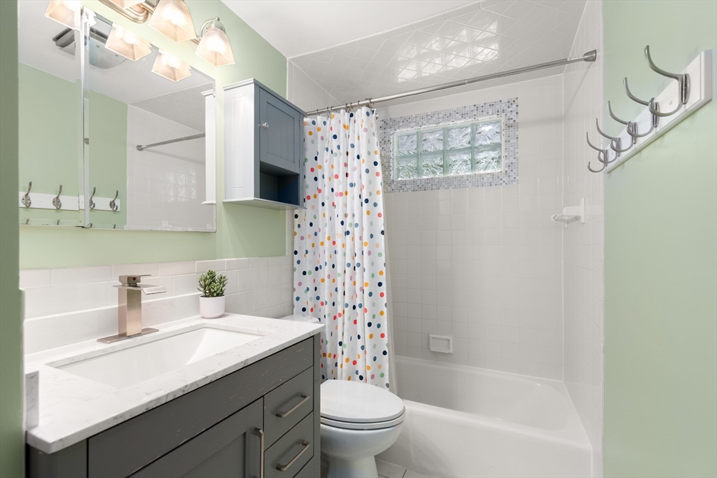 73 Willow Road Sudbury, MA 01776 - Photo 22 of 41 a bathroom with a sink a toilet and a large mirror