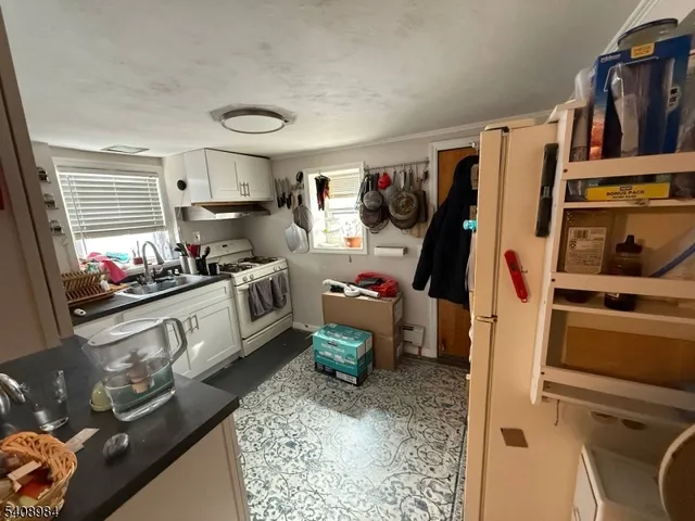 a kitchen filled with a white stove top oven and a dishwasher