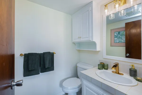 a bathroom with a sink a toilet and a mirror