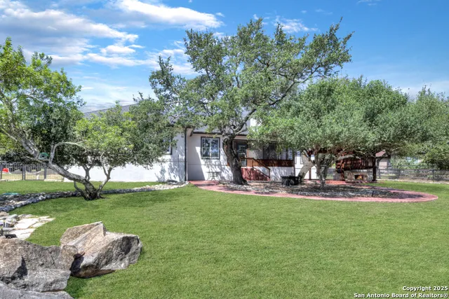 a view of a house with backyard and sitting area