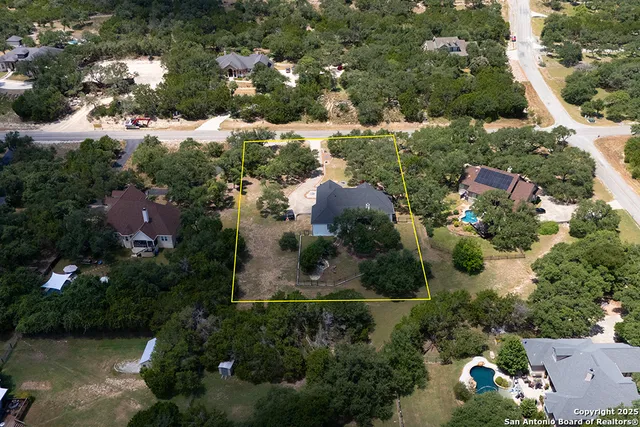 an aerial view of residential houses with outdoor space and trees