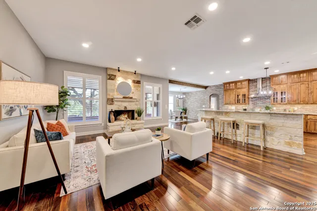 a living room with furniture fireplace and wooden floor