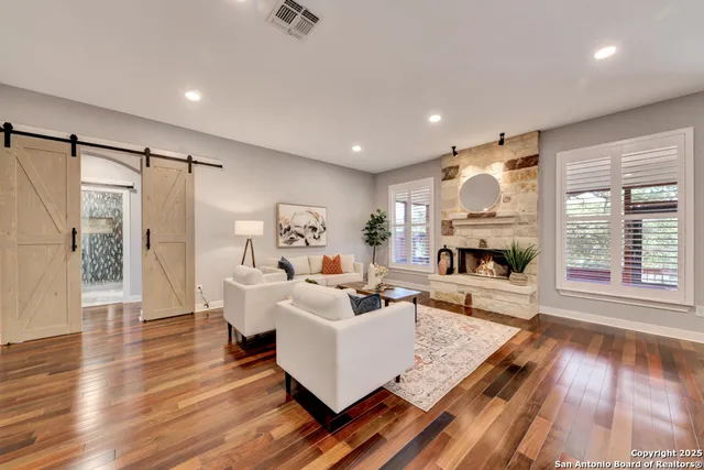 a living room with furniture fireplace and potted plant