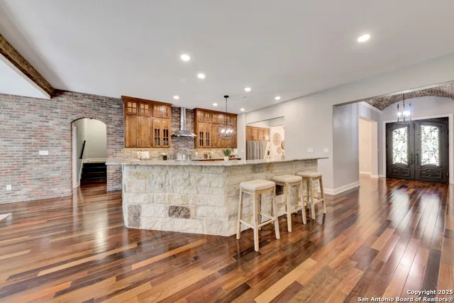 a kitchen with stainless steel appliances granite countertop a sink refrigerator and cabinets