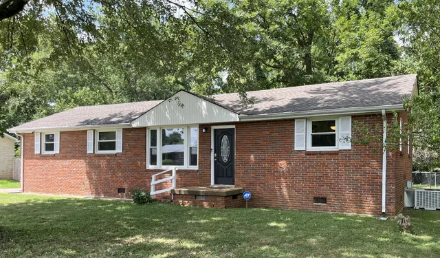 a front view of a house with a garden and yard
