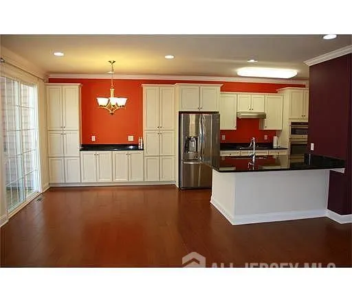 a kitchen with stainless steel appliances kitchen island sink refrigerator and cabinets