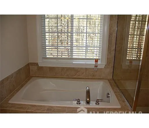 a bathroom with a tub sink and vanity