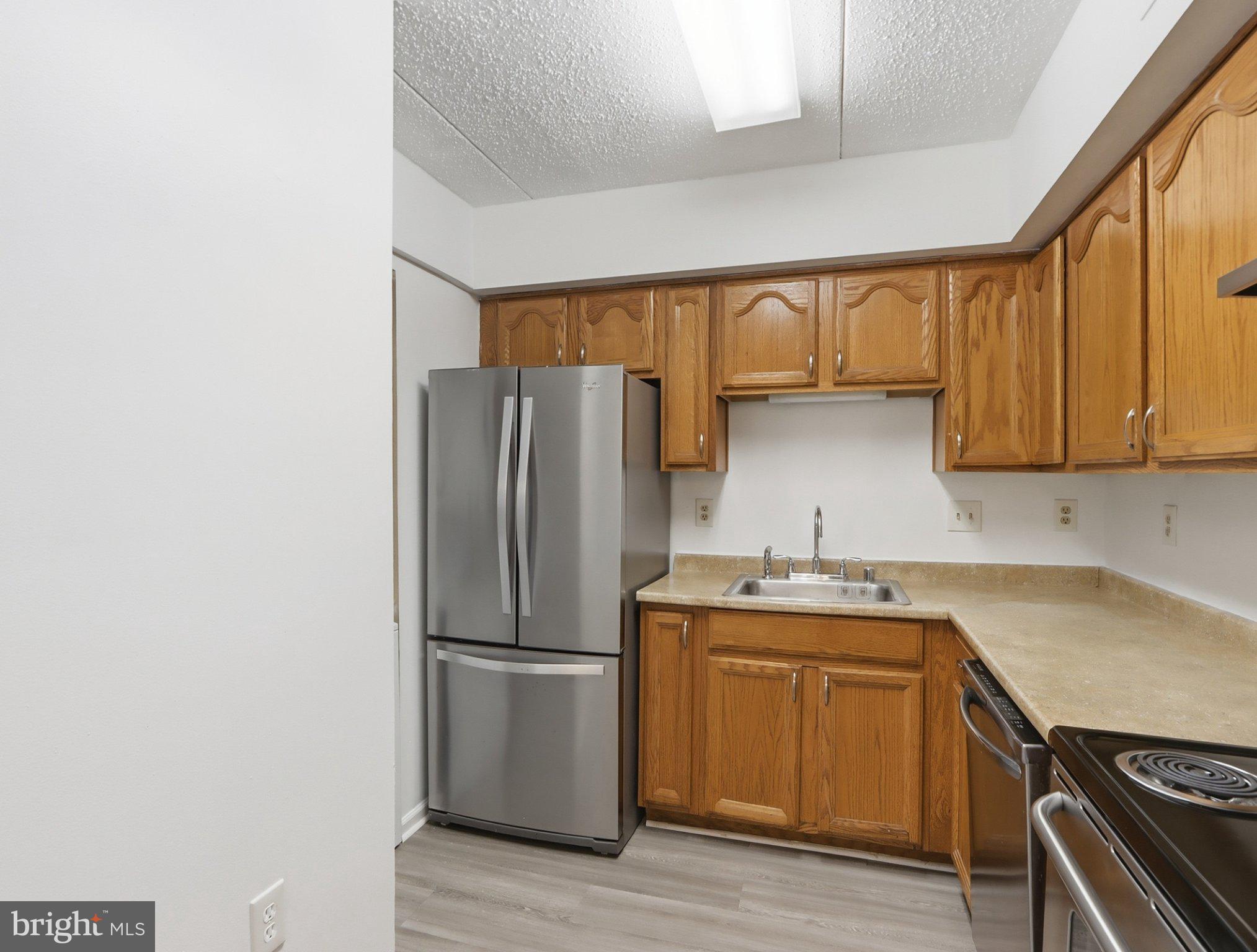 416 Terry Court, Unit A3 Frederick, MD 21701 - Photo 13 of 29 a kitchen with a sink a refrigerator and cabinets
