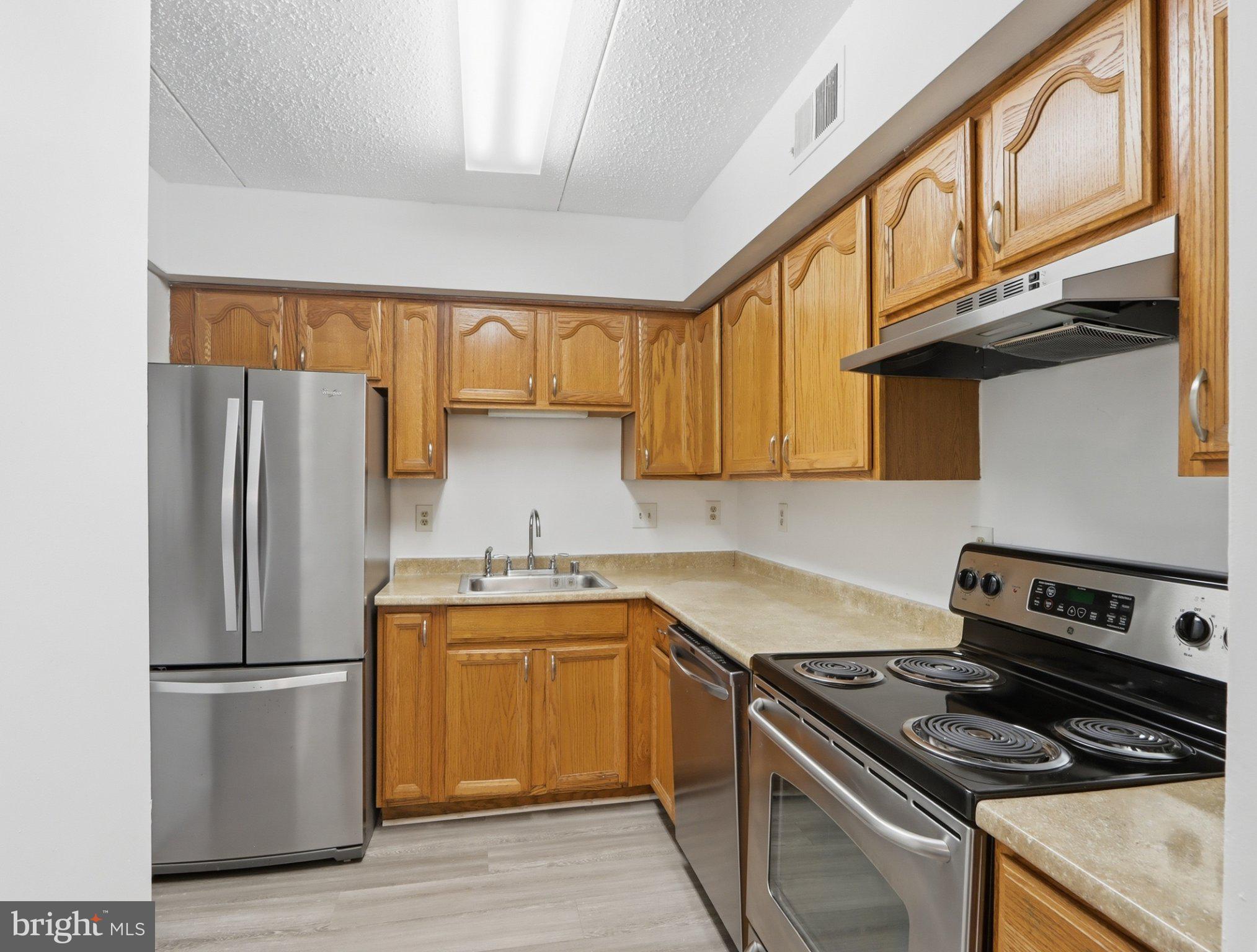 416 Terry Court, Unit A3 Frederick, MD 21701 - Photo 15 of 29 a kitchen with a sink a refrigerator and a stove top oven