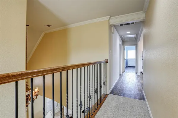 a view of a hallway with wooden floor and a bathroom