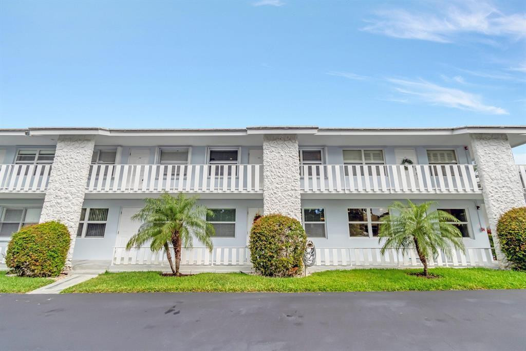 a view of a house with a patio and a yard