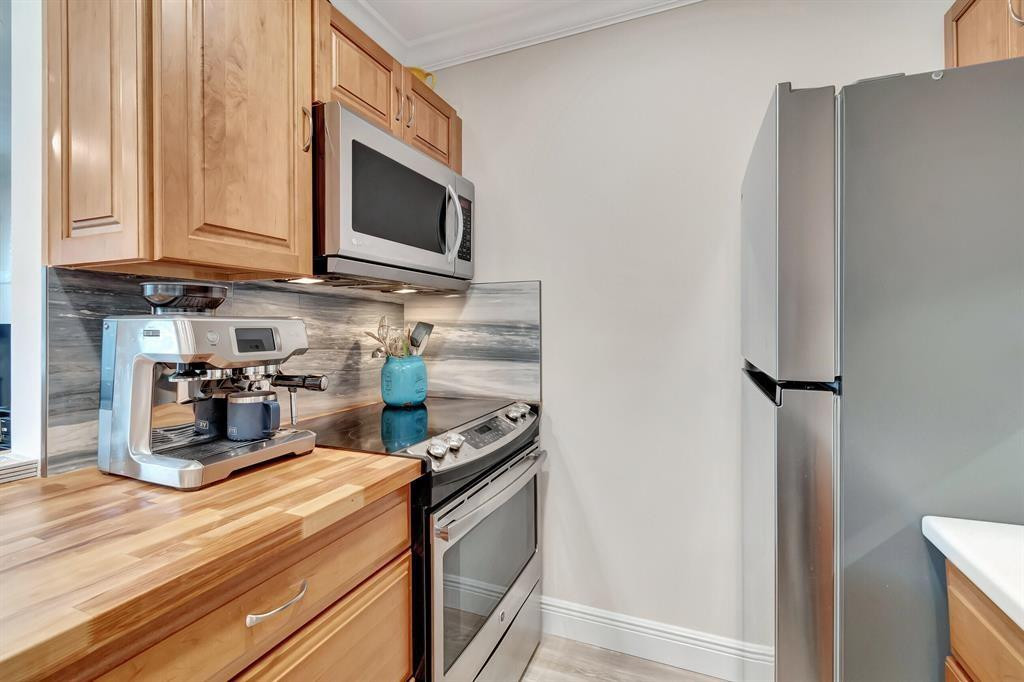 5520 North Ocean Boulevard, Unit 210 Ocean Ridge, FL 33435 - Photo 11 of 40 a kitchen with stainless steel appliances granite countertop a refrigerator a stove and a microwave