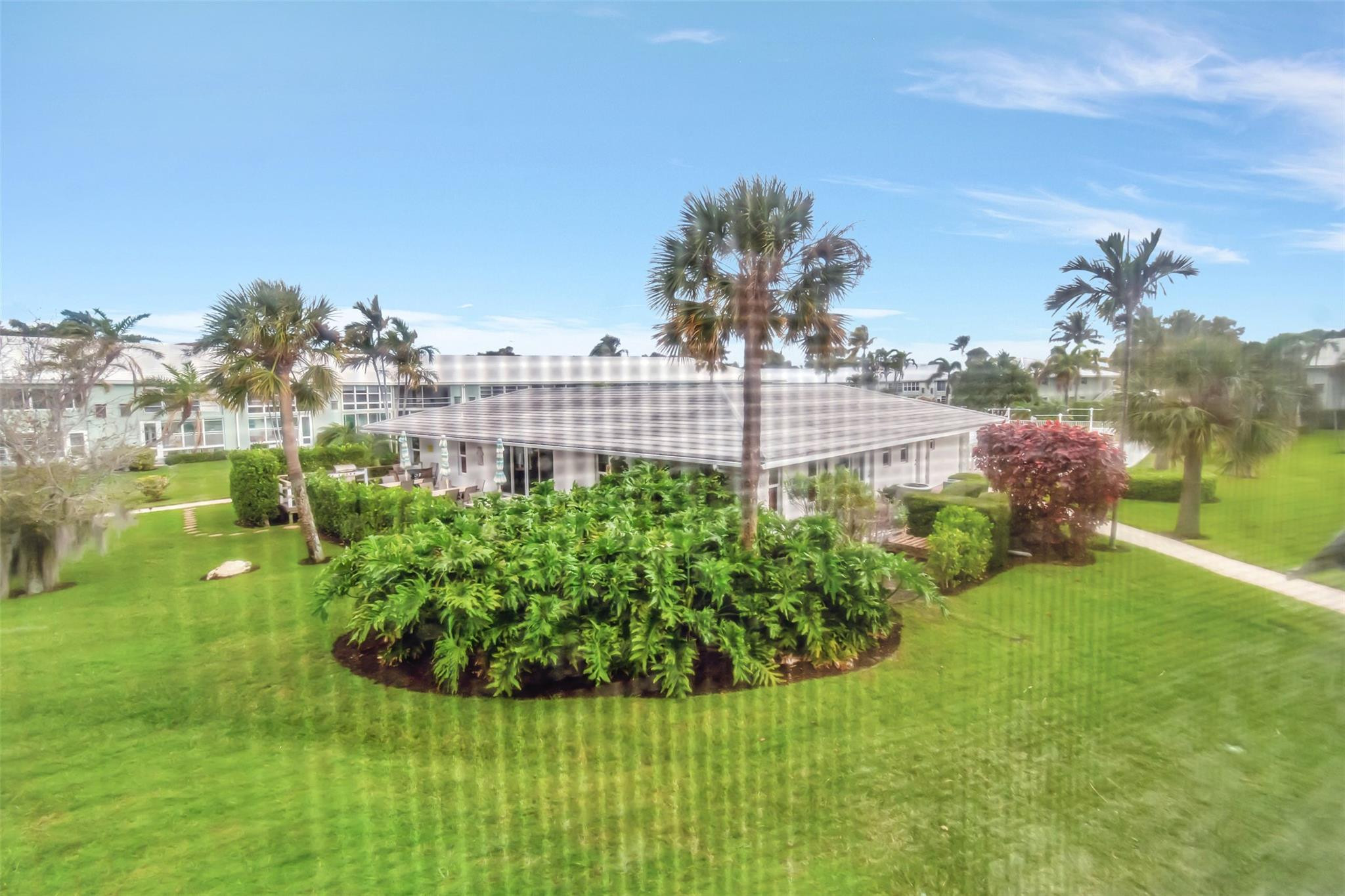 5520 North Ocean Boulevard, Unit 210 Ocean Ridge, FL 33435 - Photo 3 of 40 a view of a garden with a building in the background