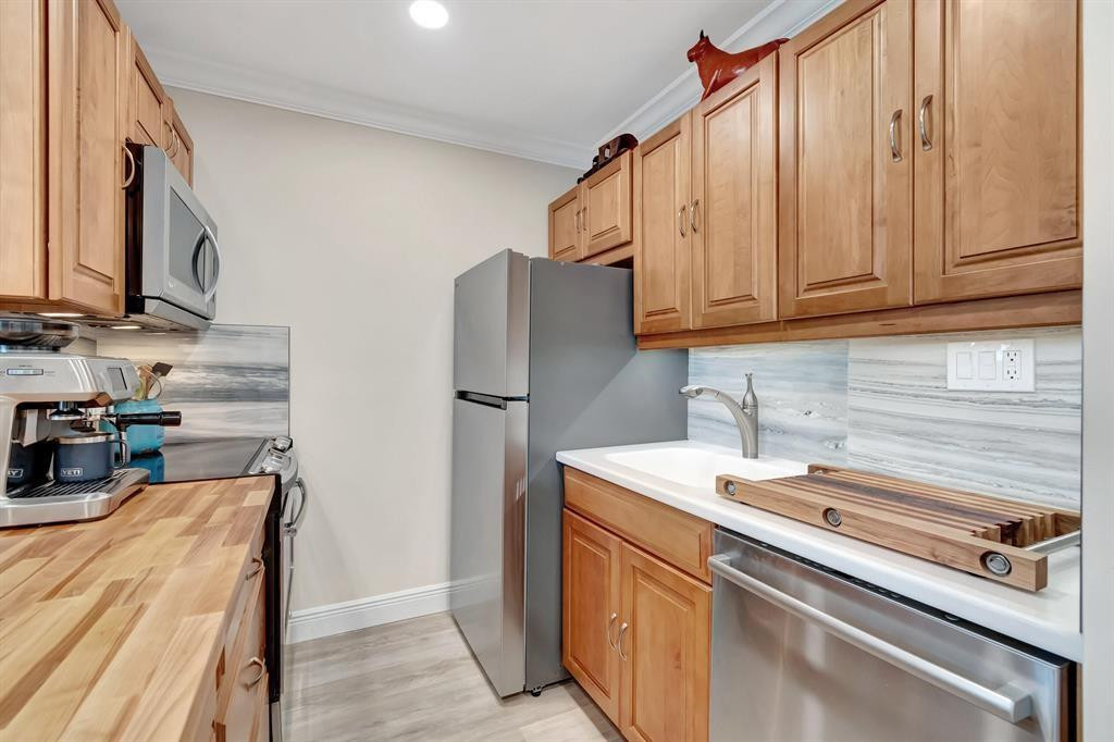 5520 North Ocean Boulevard, Unit 210 Ocean Ridge, FL 33435 - Photo 10 of 40 a kitchen with stainless steel appliances a refrigerator and a sink