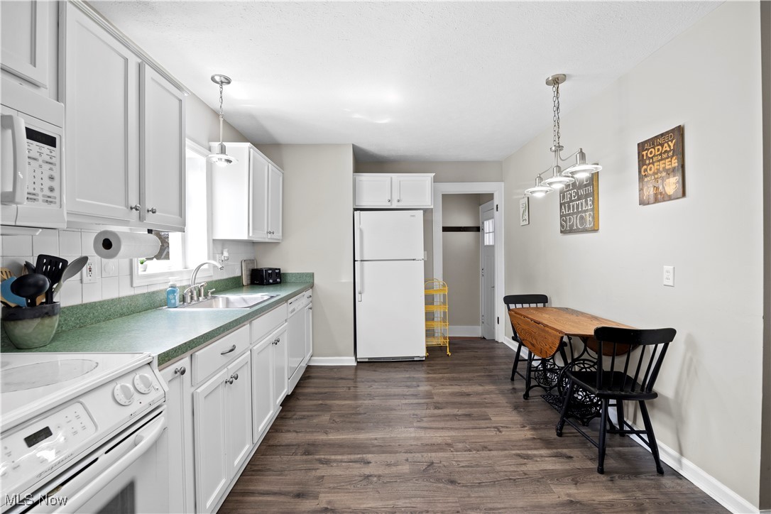 1624 Edgefield Road Lyndhurst, OH 44124 - Photo 9 of 26 Kitchen with a sink, pendant lighting, white appliances, and dark wood-style flooring