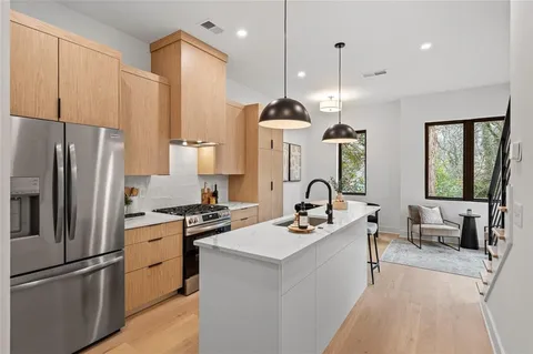 a kitchen with stainless steel appliances granite countertop a sink a stove and a refrigerator