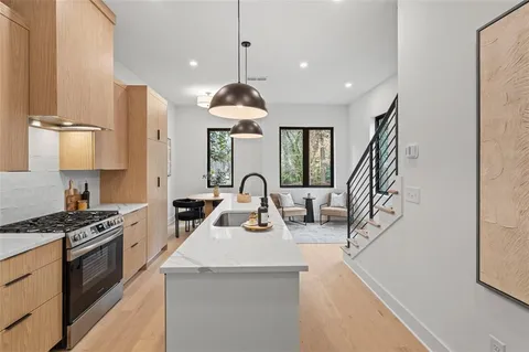 a kitchen with stainless steel appliances a sink a stove and a wooden floors