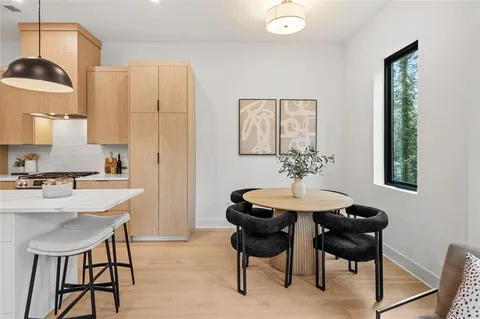 a kitchen with a sink a refrigerator and chairs