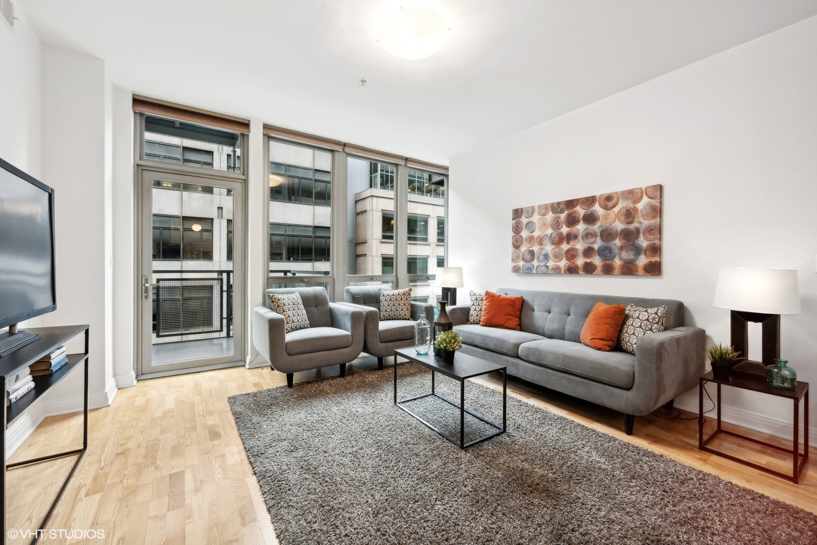 565 West Quincy Street, Unit 902 Chicago, IL 60661 - Photo 2 of 26 a living room with furniture and a flat screen tv