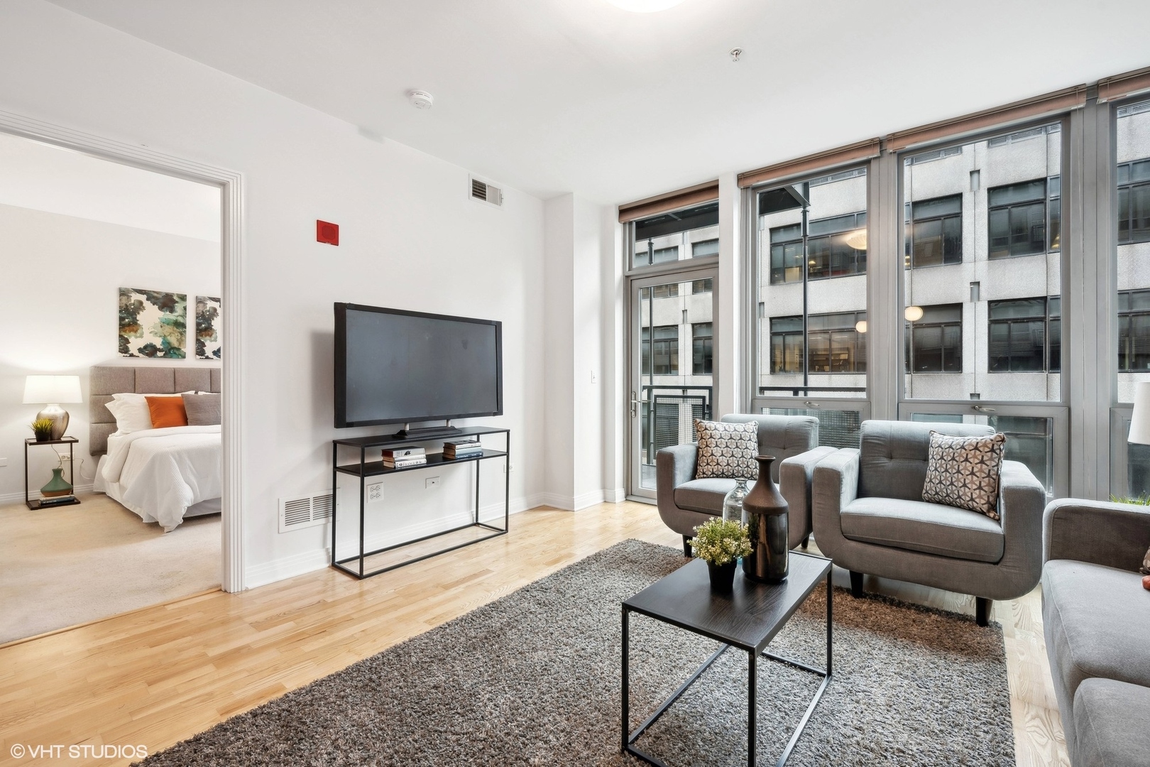 565 West Quincy Street, Unit 902 Chicago, IL 60661 - Photo 3 of 26 a living room with furniture and a flat screen tv