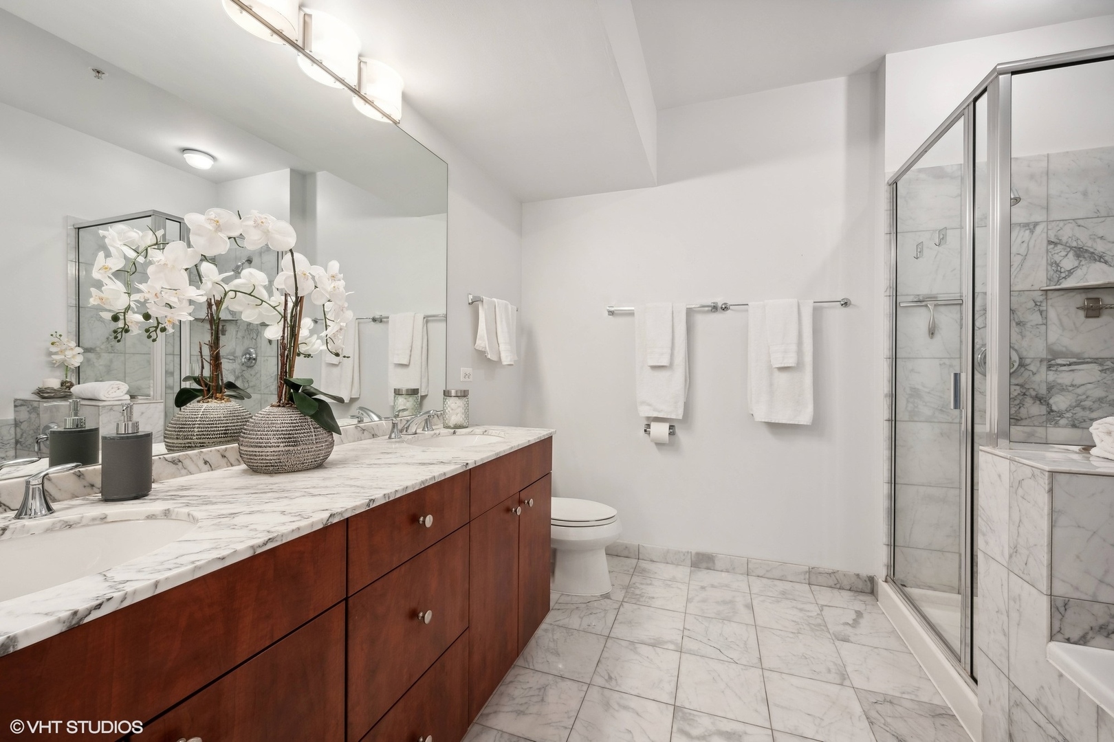 565 West Quincy Street, Unit 902 Chicago, IL 60661 - Photo 8 of 26 a bathroom with a granite countertop sink a toilet a mirror and shower