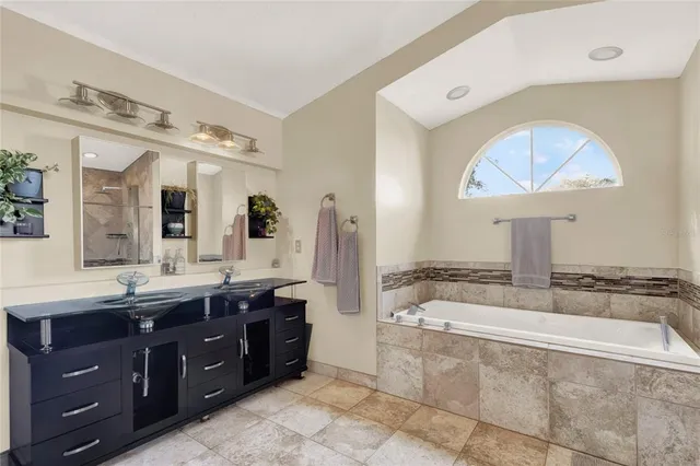 a spacious bathroom with a tub sink and mirror