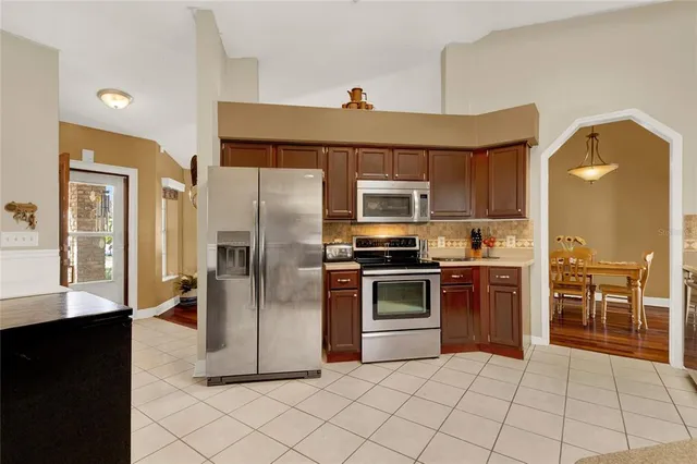 a kitchen with granite countertop a refrigerator and a stove top oven