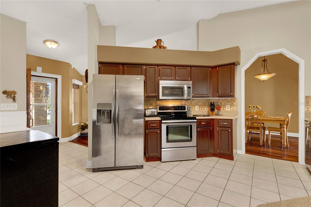 1007 Tony Circle St. Cloud, FL 34772 - Photo 5 of 20 a kitchen with granite countertop a refrigerator and a stove top oven
