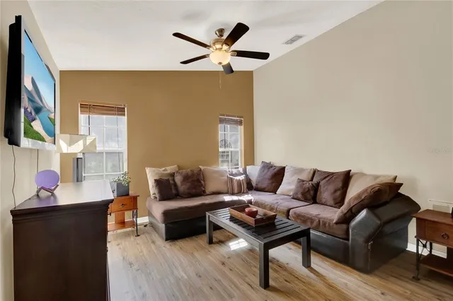 a living room with furniture and a wooden floor