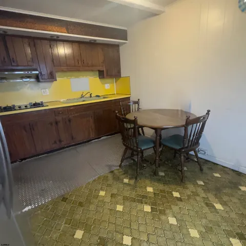 a view of water heater room with a refrigerator