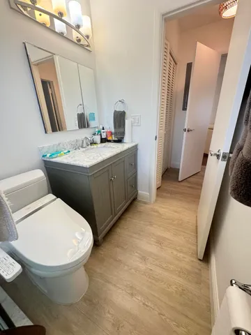 a bathroom with a granite countertop toilet sink and mirror