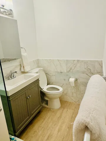a bathroom with a toilet a sink and mirror