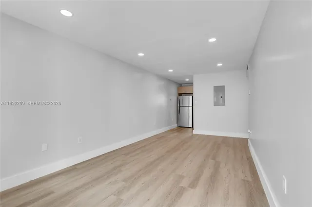 a view of an empty room with wooden floor