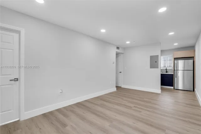 a view of an empty room with wooden floor