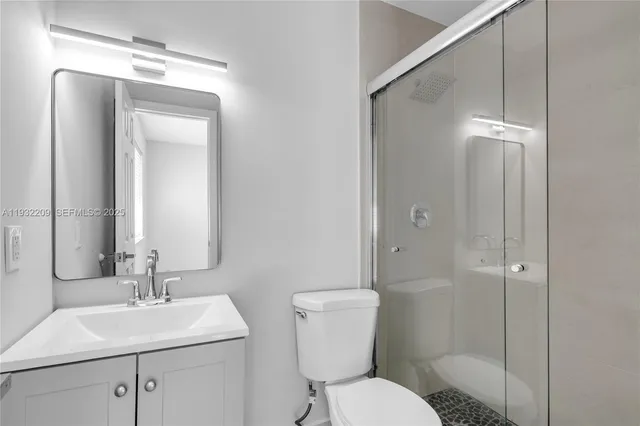 a bathroom with a toilet sink vanity and mirror