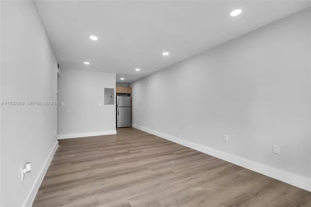 a view of an empty room with wooden floor
