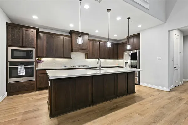a kitchen with kitchen island stainless steel appliances a sink stove and refrigerator