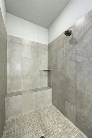 a large white bathroom with a tub shower and sink