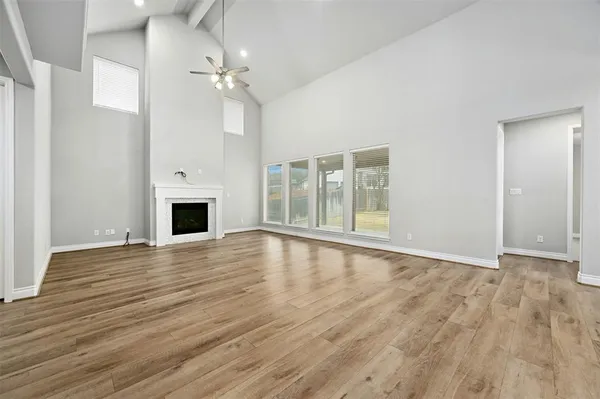 an empty room with wooden floor and fireplace