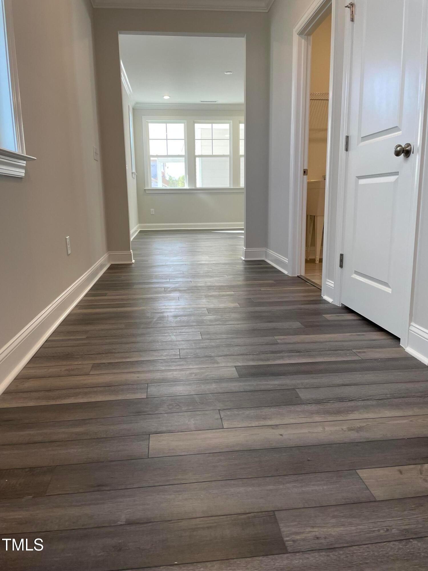 308 Edge Of Auburn Boulevard Raleigh, NC 27610 - Photo 5 of 23 wooden floor in an empty room with a window