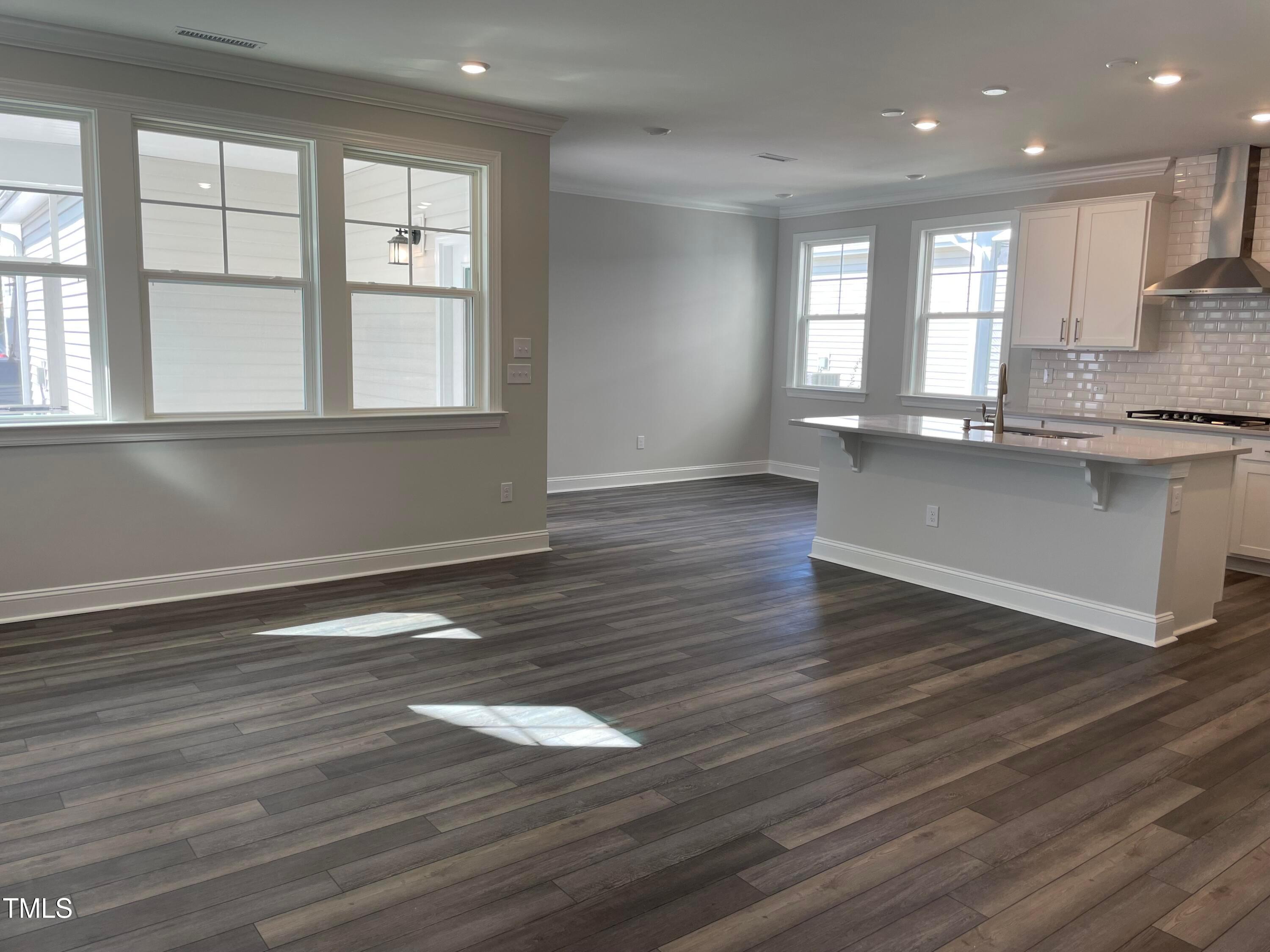 308 Edge Of Auburn Boulevard Raleigh, NC 27610 - Photo 6 of 23 an empty room with wooden floor and windows